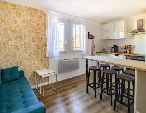 une cuisine avec une table et des tabourets dans une pièce dans l'établissement T4 plein coeur de Marseille avec vue Notre Dame, à Marseille