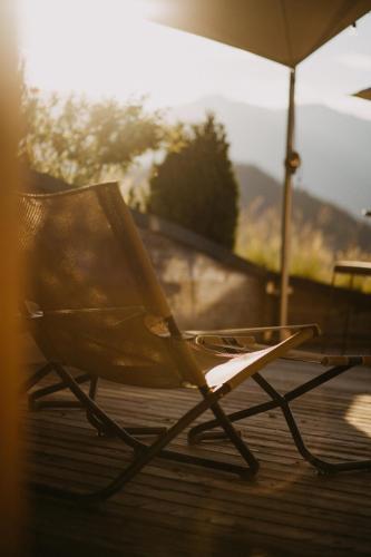 a chair sitting on a deck with an umbrella at Salzbergalm in Berchtesgaden