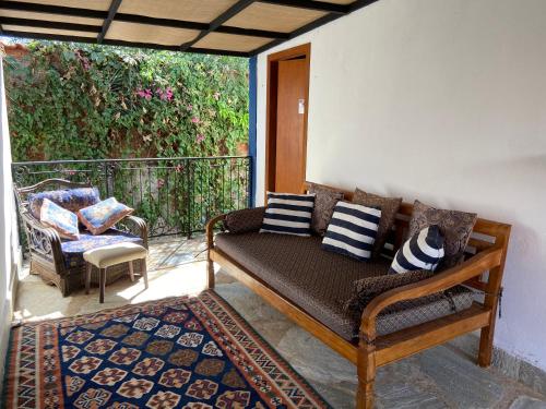 a porch with a couch and a chair on a balcony at Casarão Coimbra Pousada Colonial in Pirenópolis