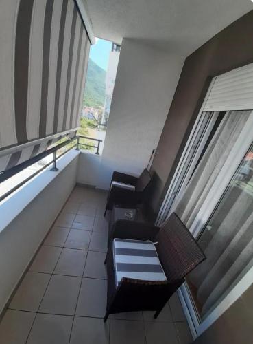 a balcony with two chairs and a table in a building at Dijana apartman in Tomičići