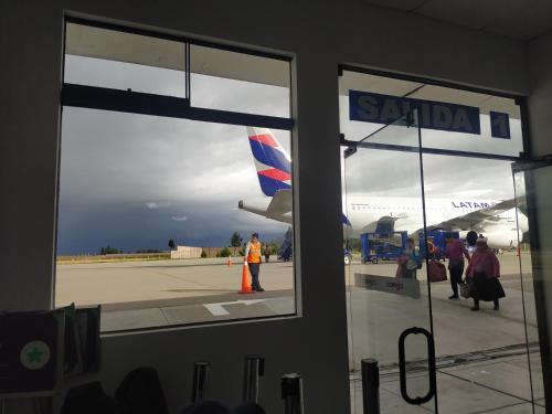 a person standing in front of an airplane outside a window at SumaqWasi Huaripampa in Jauja