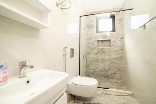 a bathroom with a shower and a toilet and a sink at Rine Apartments in Ulcinj