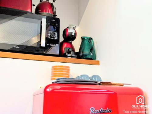 une valise rouge et un four micro-ondes sur une étagère dans l'établissement Ô Cocon - Central - Climatisé - Poutres apparentes, à Orléans