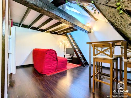 - un salon avec une chaise rouge et une échelle dans l'établissement Ô Cocon - Central - Climatisé - Poutres apparentes, à Orléans