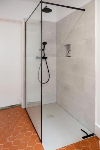 une douche avec une porte vitrée dans une salle de bain dans l'établissement Mistral126, à Aix-en-Provence