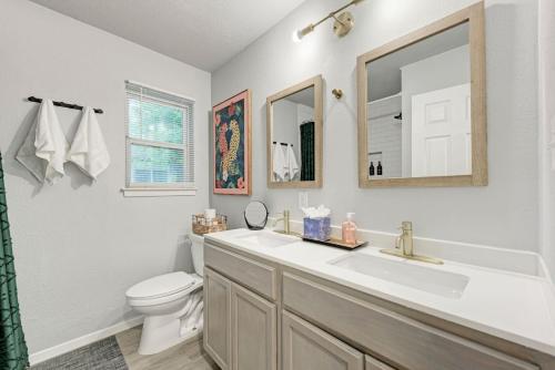 a bathroom with a sink and a toilet and a mirror at Pink Fun Home - Minutes to Downtown-AUS in Austin