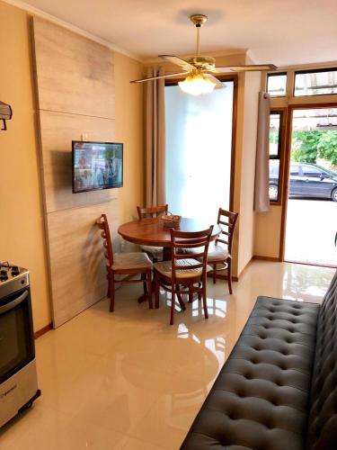 a dining room with a table and chairs and a television at Apartamentos Piriapolis in Piriápolis