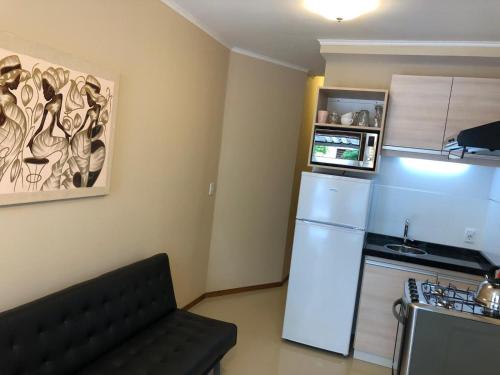 a small kitchen with a refrigerator and a microwave at Apartamentos Piriapolis in Piriápolis