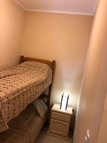 a small bedroom with a bed and a night stand at Apartamentos Piriapolis in Piriápolis