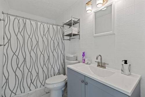 Un baño con lavabo, inodoro y espejo. en Spacious Family Suite Steps to the Beach (444), en Old Orchard Beach