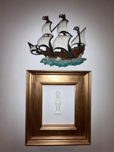 a picture of a pirate ship in a gold picture frame at The Scholar Suite with 1 King in Columbia