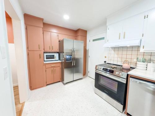 a kitchen with wooden cabinets and a stainless steel refrigerator at The Flamingo Suite 1 King in Columbia