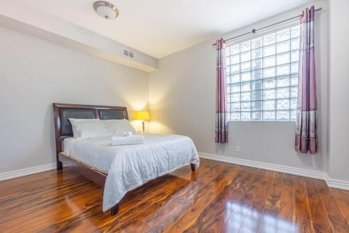 a bedroom with a bed and a large window at Bright 1BR Apt with Niagara Falls and Scenic Stay in Niagara Falls