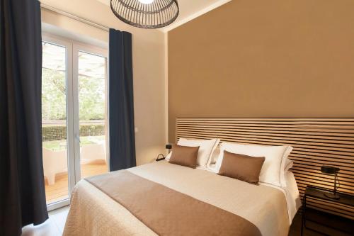 a bedroom with a bed and a large window at Country Resort Le Due Ruote in Alberese