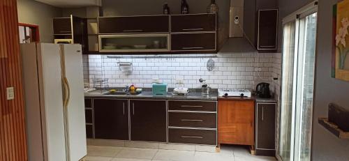 a kitchen with brown cabinets and a refrigerator at Depto Arenales in Barrio Esteban Echeverría