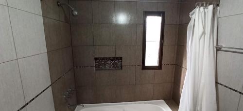 a bathroom with a shower with a toilet and a window at Depto Arenales in Barrio Esteban Echeverría