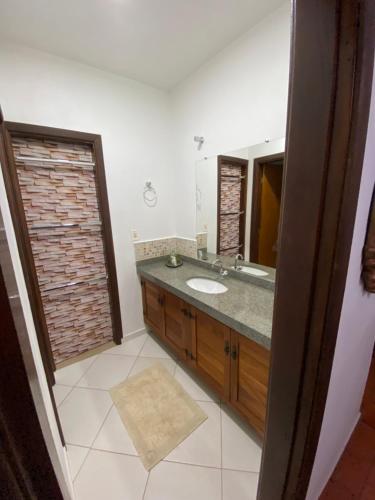 a bathroom with a sink and a mirror at Casarão Coimbra Pousada Colonial in Pirenópolis