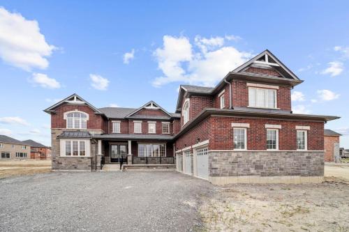 a large brick house with a driveway at Prime Peterborough - 4BR and Office, Newly Renovated in Peterborough