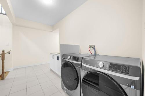 a kitchen with a washer and dryer in a room at Prime Peterborough - 4BR and Office, Newly Renovated in Peterborough