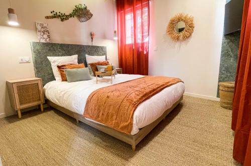 a bedroom with a large bed with an orange blanket at L'atelier vert - Suite Luxe, SPA, Proche Hypercentre - Classé 4 étoiles in Troyes