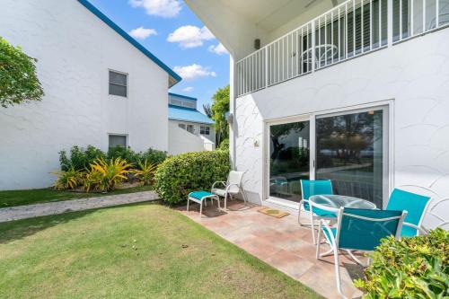 a patio with chairs and a table in front of a house at Beachfront Condo next to Ritz in West Bay