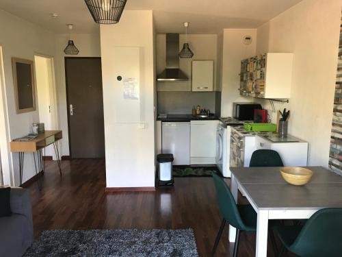 une cuisine avec des placards blancs, une table et une table dans l'établissement ENTRE TERRE ET MER, à Ajaccio