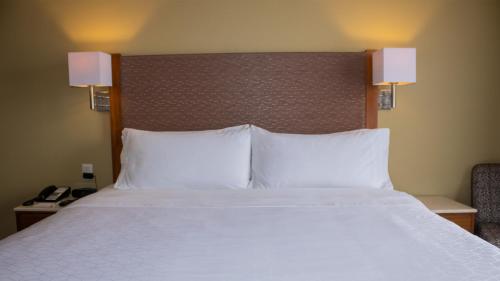 a large bed with white sheets and pillows in a hotel room at Holiday Inn Orizaba by IHG in Orizaba