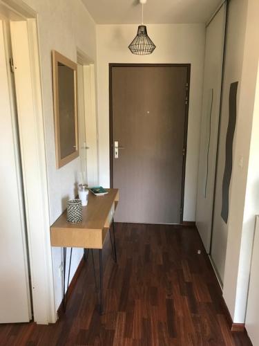 un couloir avec une table en bois et une porte dans l'établissement ENTRE TERRE ET MER, à Ajaccio