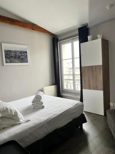 une chambre avec un lit et une fenêtre dans l'établissement Superbe appartement proche du Marais, à Paris