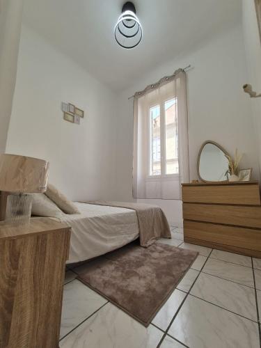 une chambre avec un lit, un miroir et une fenêtre dans l'établissement cosy t-3 proche velodrome,plages idéalement situé, à Marseille