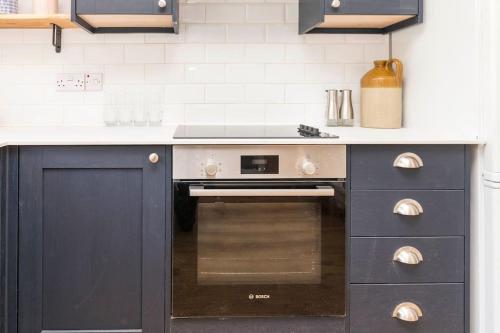 a kitchen with a stove and a counter top at Well-equipped Apartment at Westerlands Farm in Graffham