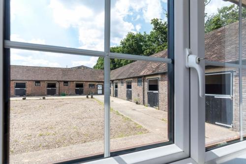 an open window with a view of a building at Well-equipped Apartment at Westerlands Farm in Graffham