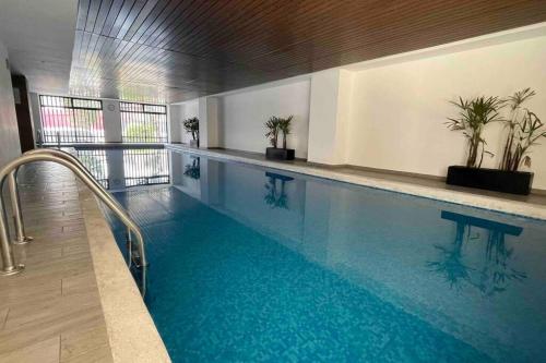 a large swimming pool with blue water in a building at Loft MIXCOAC cerca de Todo - Trabajo o descanso - Alberca y Gym in Mexico City