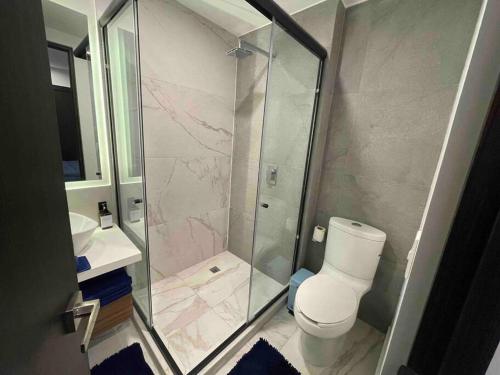 a bathroom with a shower with a toilet and a sink at Loft MIXCOAC cerca de Todo - Trabajo o descanso - Alberca y Gym in Mexico City