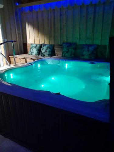 a jacuzzi tub with blue lighting in a room at Love-Room Spa de la TRUFFIERE in Bertric-Burée