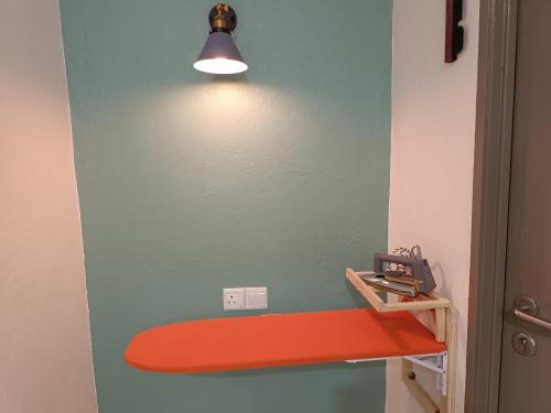 a room with an orange shelf and a light on a wall at Alameen Boutique Hotel in Kangar