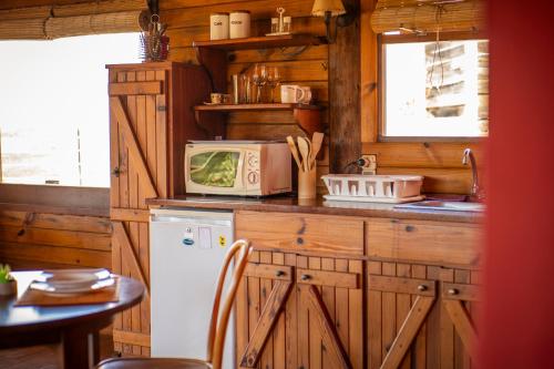 a kitchen with a refrigerator and a microwave at En calma in Punta Del Diablo