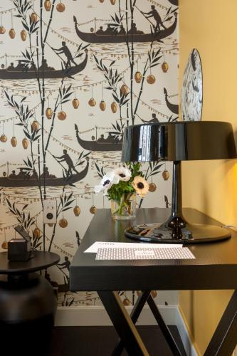 a black table with a lamp and a wall at Hôtel Mathis Elysées in Paris