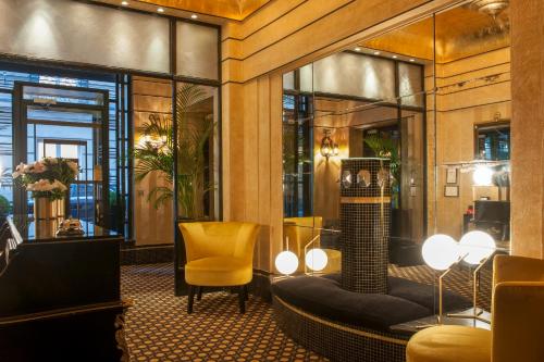 a hotel lobby with a yellow chair and windows at Hôtel Mathis Elysées in Paris