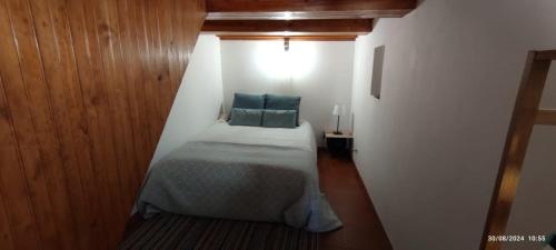 a small bedroom with a bed with a blue pillow at Casa do Outeirinho in Castelo de Vide