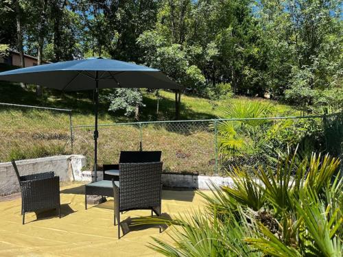 a table and chairs with an umbrella on a patio at Gîte 6 personnes avec piscine in Agnac