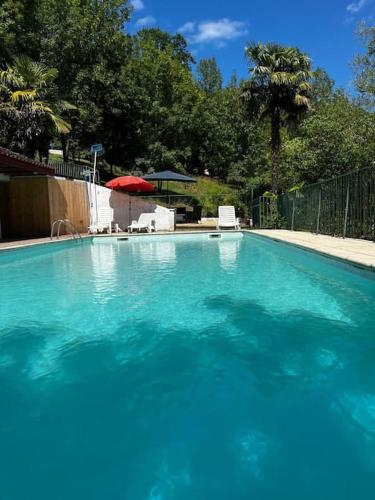 a large pool of blue water in a yard at Gîte 6 personnes avec piscine in Agnac