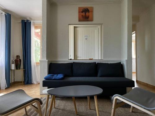 a living room with a blue couch and a table at Gîte 6 personnes avec piscine in Agnac