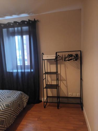 a room with a shelf next to a bed and a window at Maison meublée avec parking in Moulins