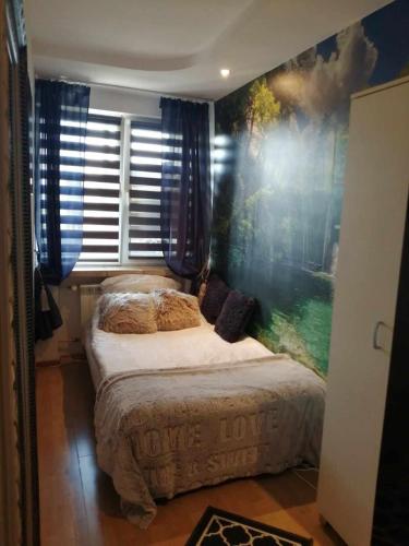 a bedroom with a large painting on the wall at Apartamenty na doby in Siedlce