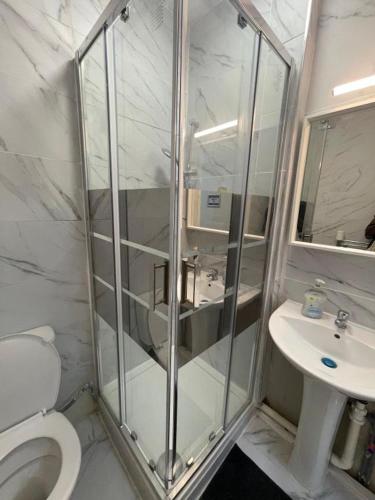 a bathroom with a shower and a toilet and a sink at Sterling Suites Ealing in Ealing