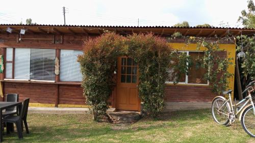 a house with a wooden door and vines at Hospedaje Gratitud Guatavita in Guatavita