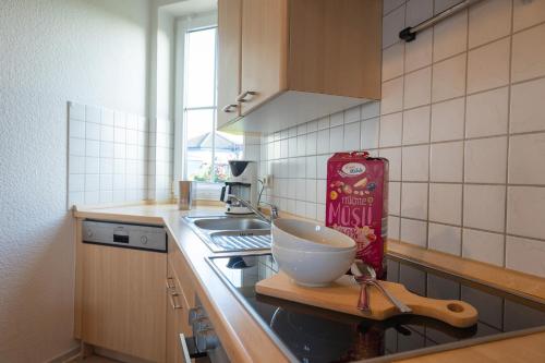 a kitchen with a bowl on a counter next to a sink at Ferienhaus Achteck am Deich, Graureiherweg 4a in Dorum Neufeld