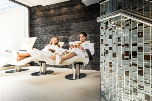 a couple sitting in chairs in a spa room at Sport- und Genusshotel Silvretta in Ischgl