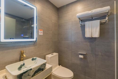 a bathroom with a toilet and a sink and a mirror at Qinfu Hotel Beijing Nanluogu Lane Houhai in Beijing